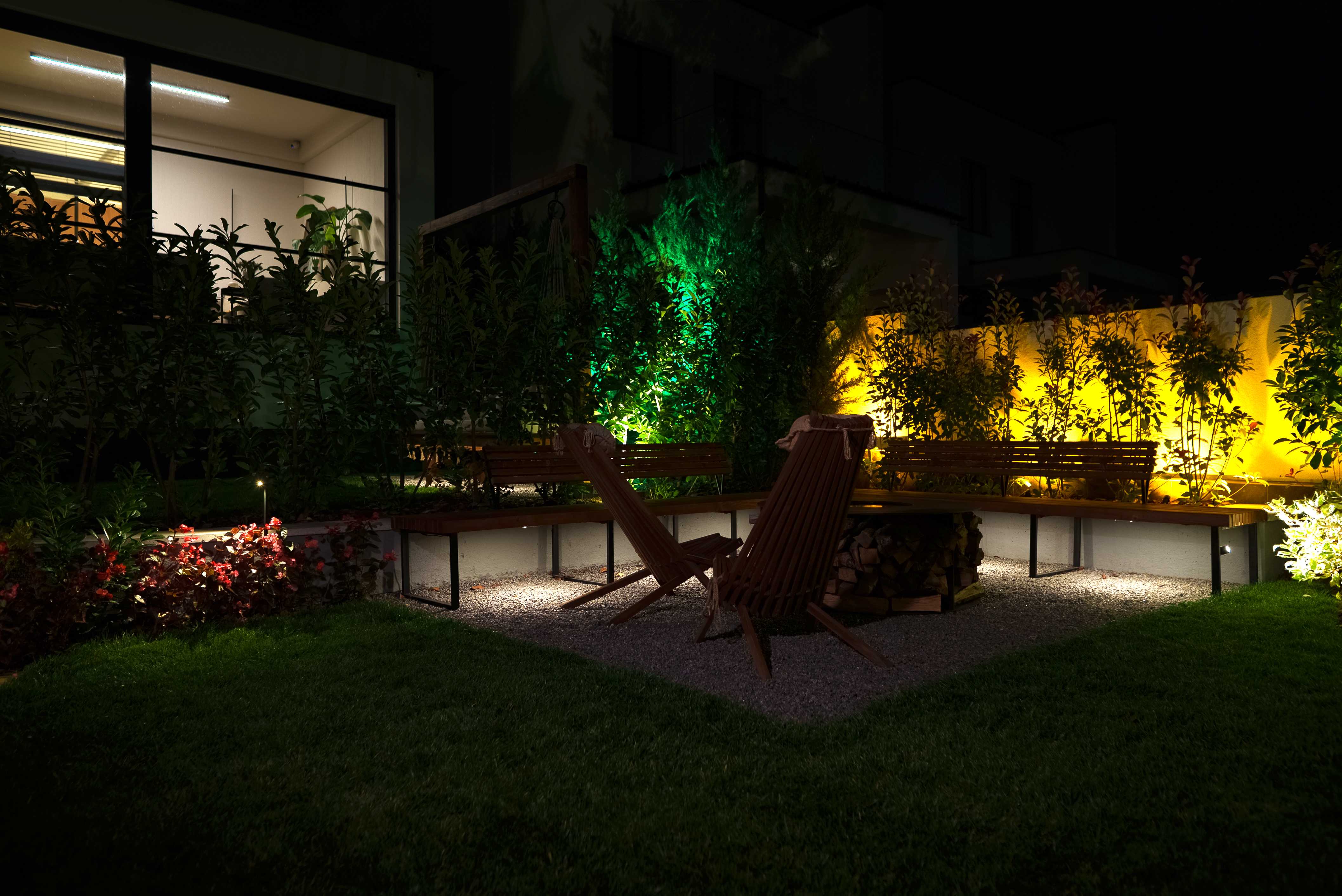 Lounge garden featuring dynamic green and amber lighting on privacy screens